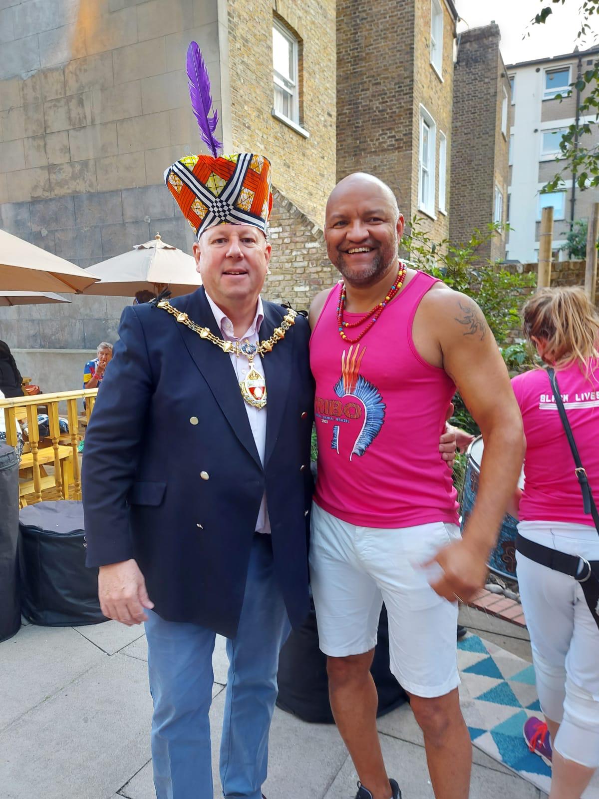 Marcos Santana in a TRIBO vest standing with a London mayor wearing ceremonial chains and a TRIBO headdress