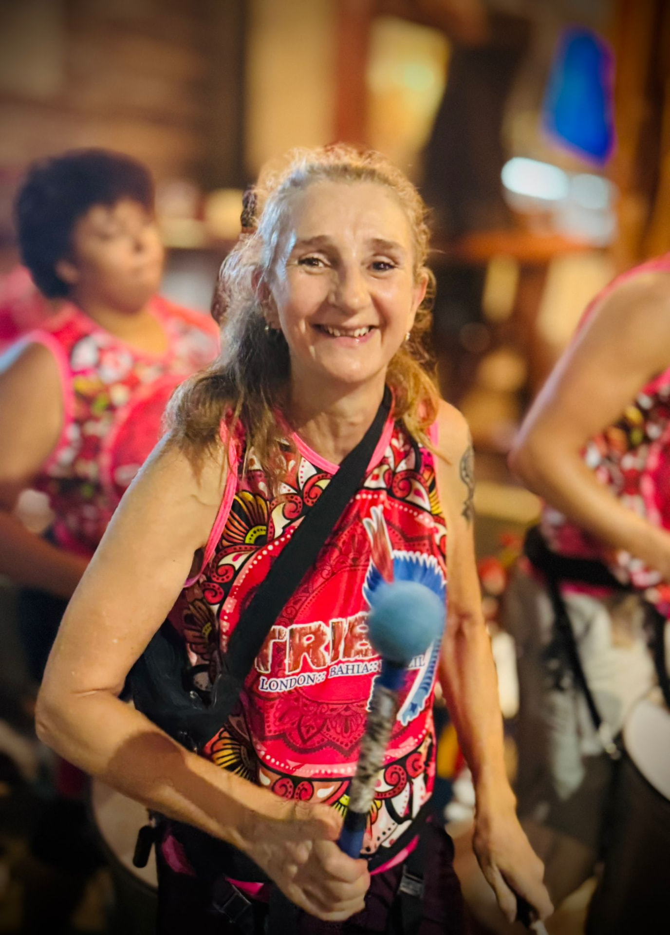TRIBO member smiling while playing during a street performance at night