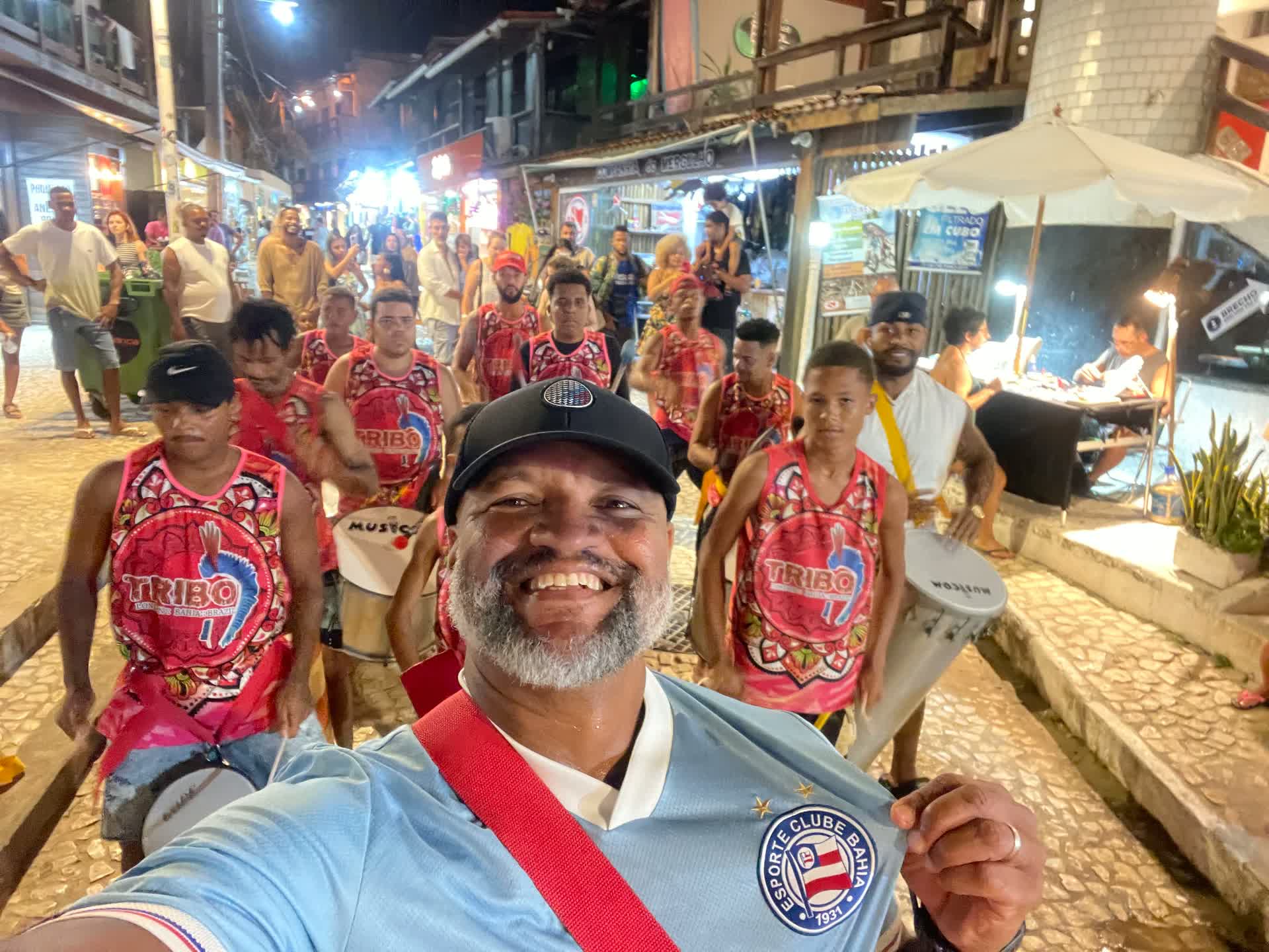 TRIBO drummers parading at night along a cobblestone street in Bahia