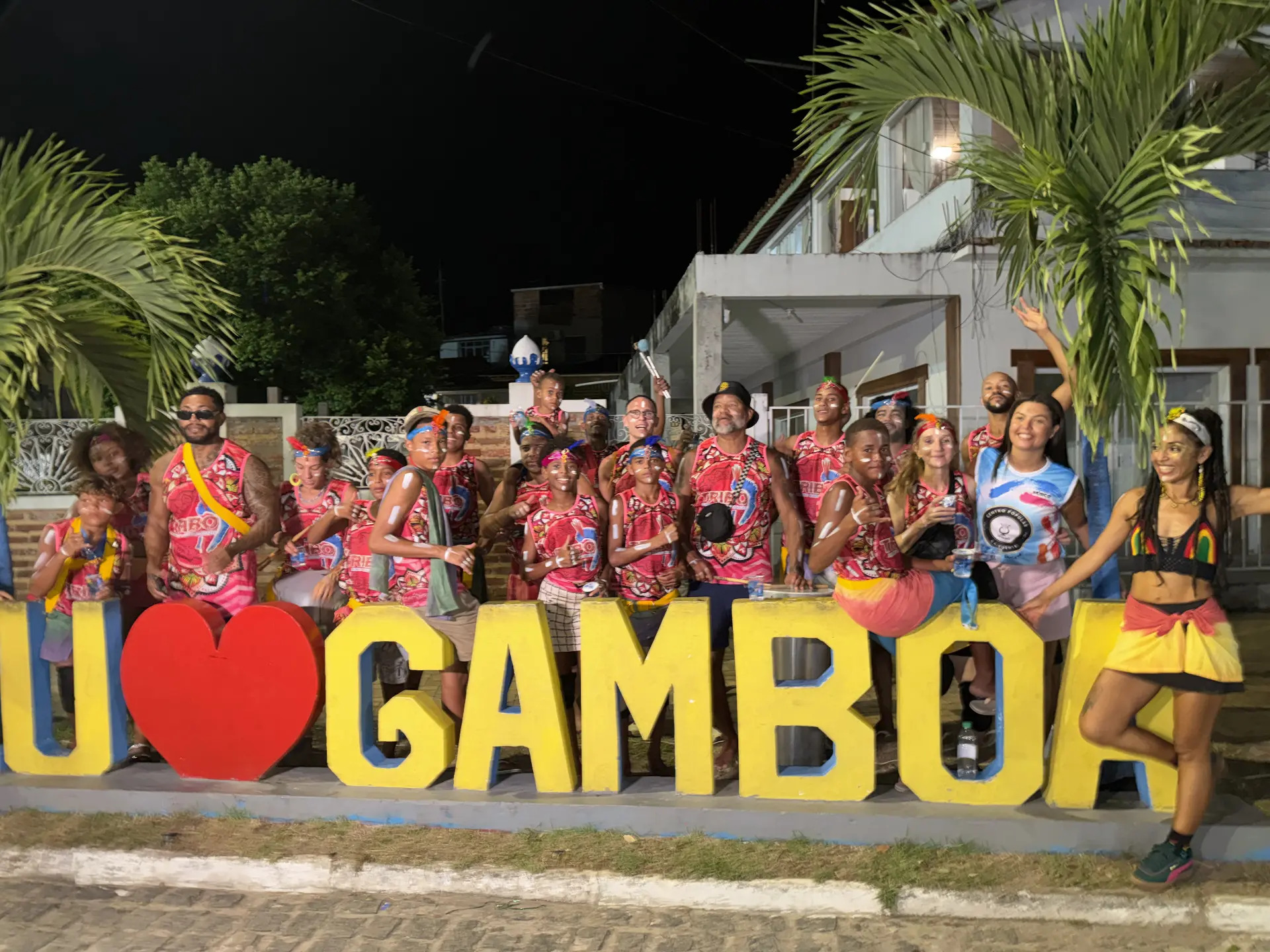 TRIBO bloco gathered at the Eu Amo Gamboa sign during carnival, drummers in band vests